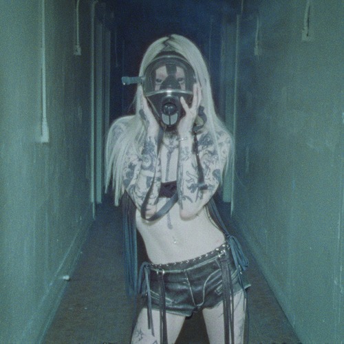 yeule – Hystérique single cover: a washed-out blue photo of yeule in a narrow corridor, platinum hair, tattooed arms raised to a gas mask, wearing low-slung fringed shorts